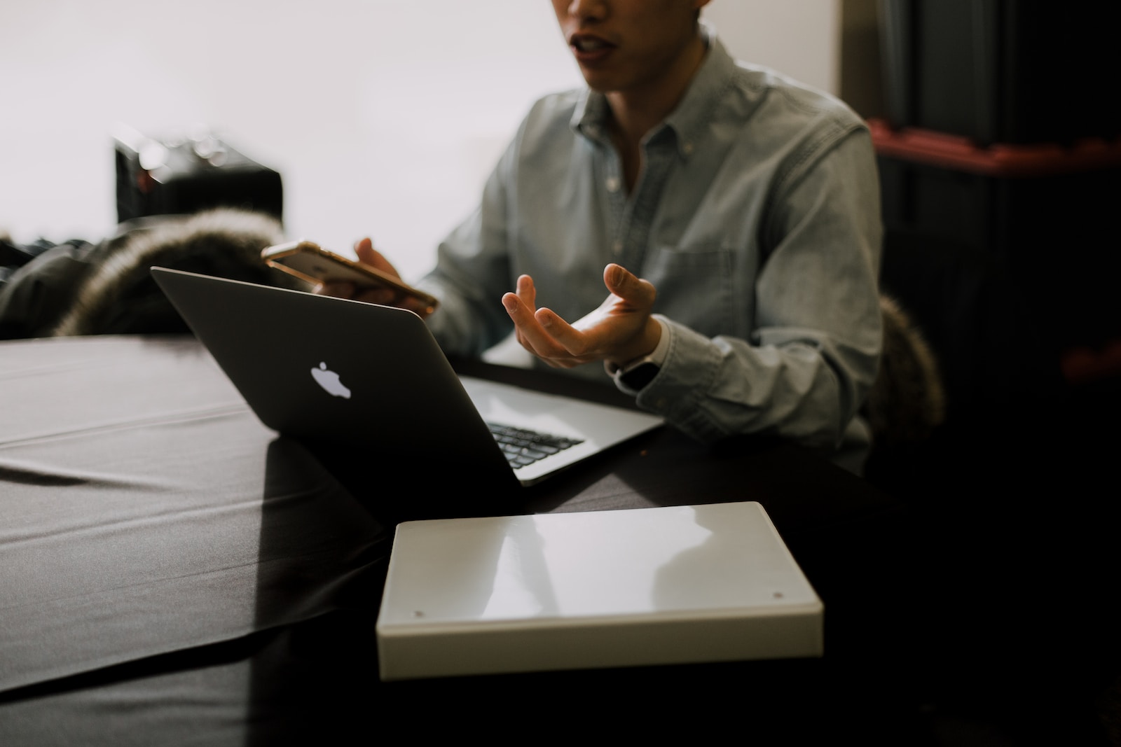 Photo by Priscilla Du Preez ?? a man sitting at a table with a laptop in front of him